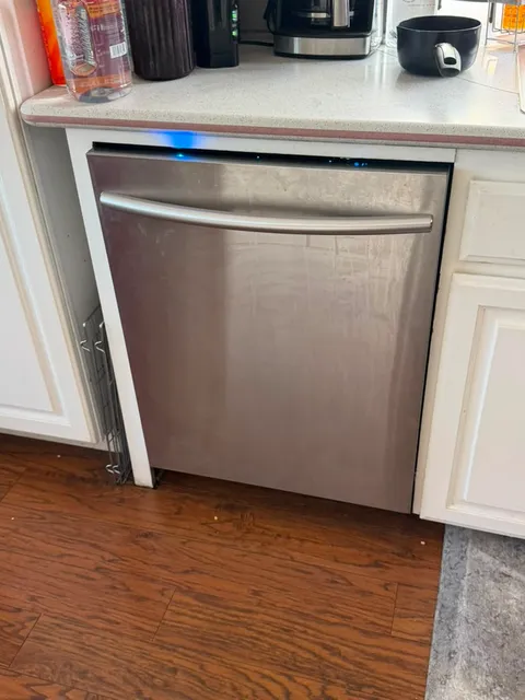 Stainless Samsung built-in dishwasher installed under a Lake Forest kitchen counter with its status light lit after a drain pump replacement