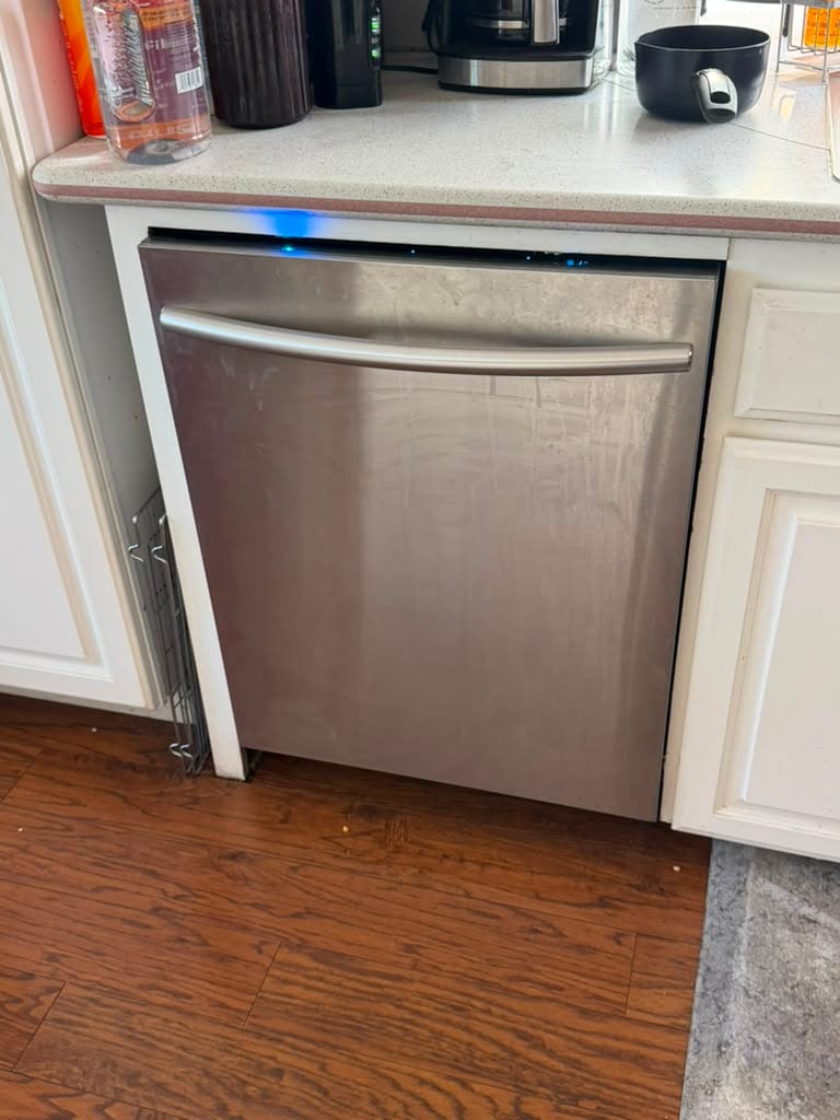 Stainless Samsung built-in dishwasher installed under a Lake Forest kitchen counter with its status light lit after a drain pump replacement
