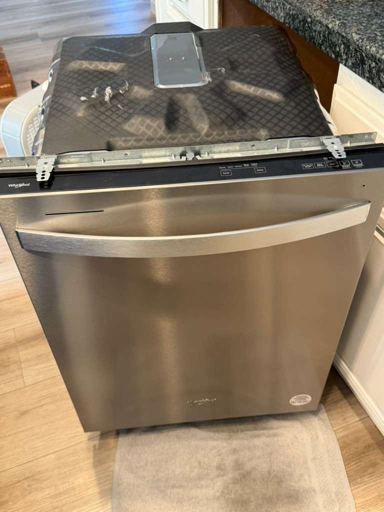 Stainless Whirlpool built-in dishwasher pulled from the cabinet in a San Clemente kitchen, serviced for a water leak