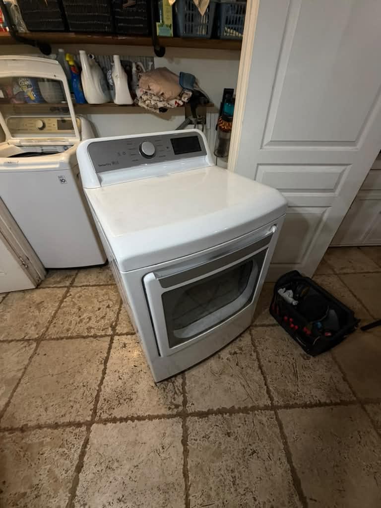 White LG front-load dryer with a SmartThinQ-style control panel beside an LG top-load washer in an Anaheim laundry closet