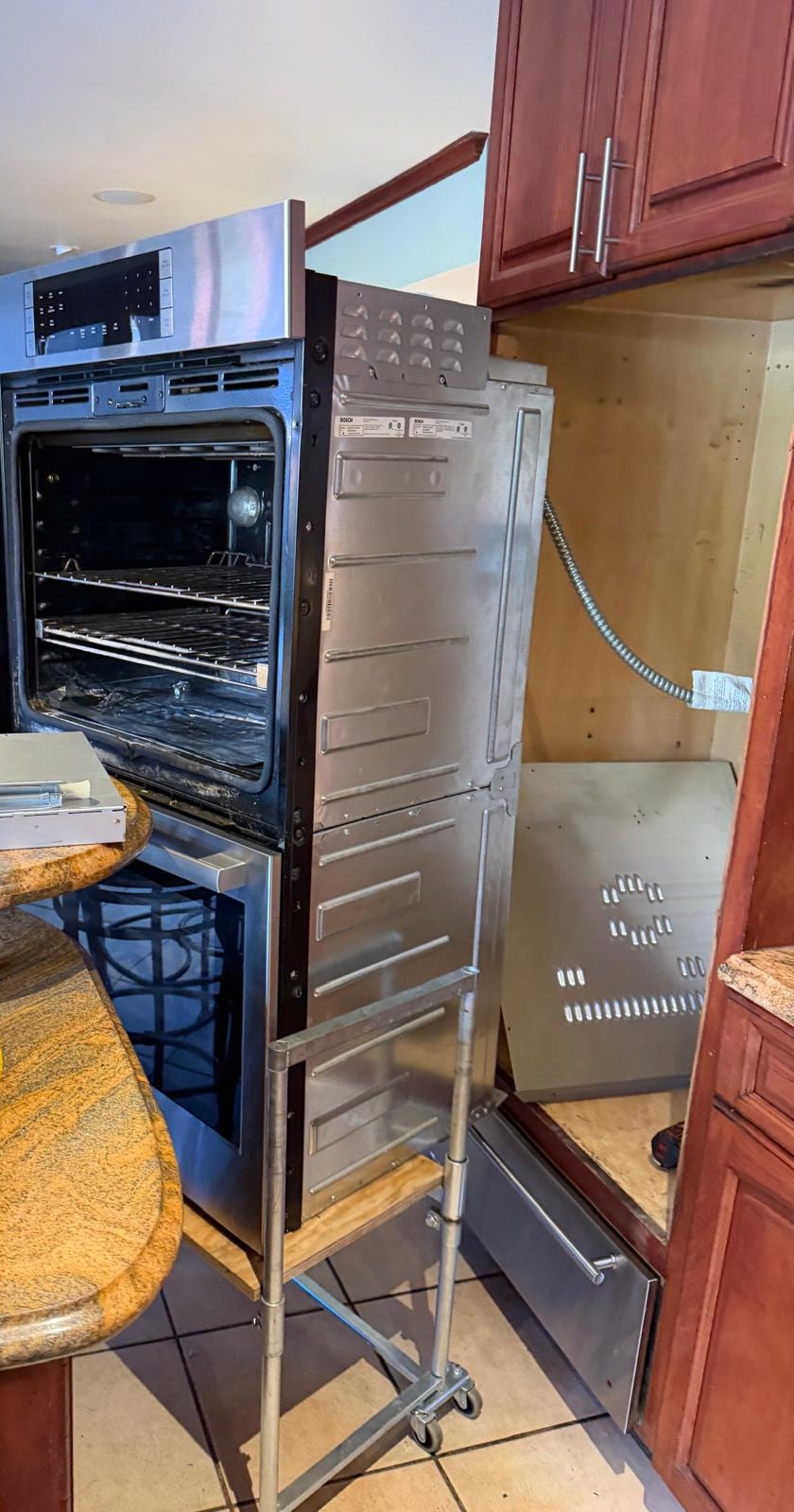 Bosch built-in double wall oven pulled forward with its service panel open in a Newport Beach kitchen