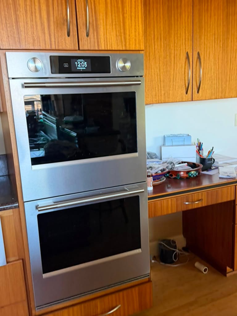 Newly installed KitchenAid stainless built-in double wall oven powered on in a Tustin kitchen