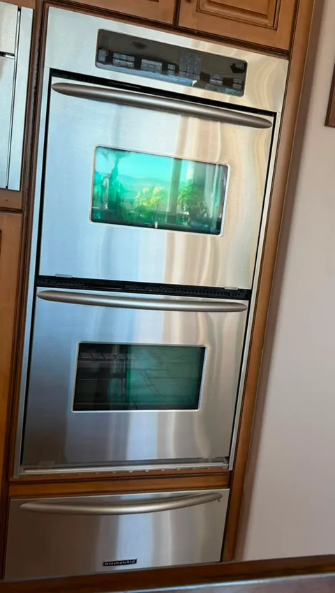 KitchenAid stainless built-in double wall oven with a warming drawer below, set into maple cabinetry in an Irvine kitchen after an oven temperature sensor replacement