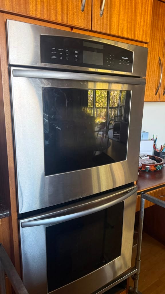 Thermador stainless double wall oven in its cabinet opening before removal in a Tustin kitchen