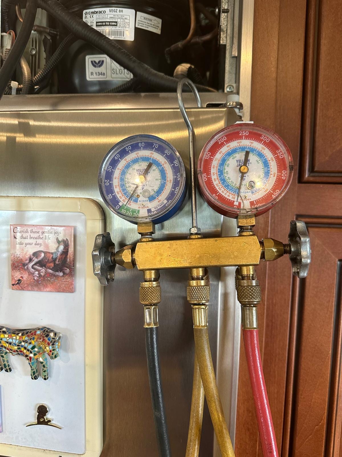 Service gauges connected at a GE Monogram refrigerator during a documented compressor replacement in Laguna Beach