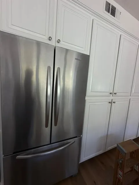 Stainless KitchenAid French-door refrigerator set into white cabinetry in a San Clemente kitchen