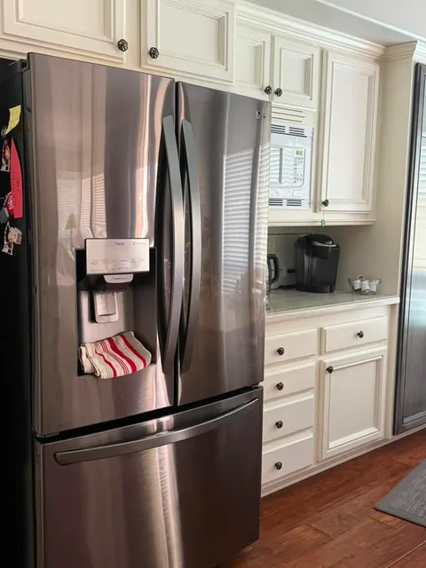 LG French-door refrigerator with a through-door ice and water dispenser panel, standing in a Rancho Santa Margarita kitchen with cream cabinetry, after a water filter and water filter housing replacement