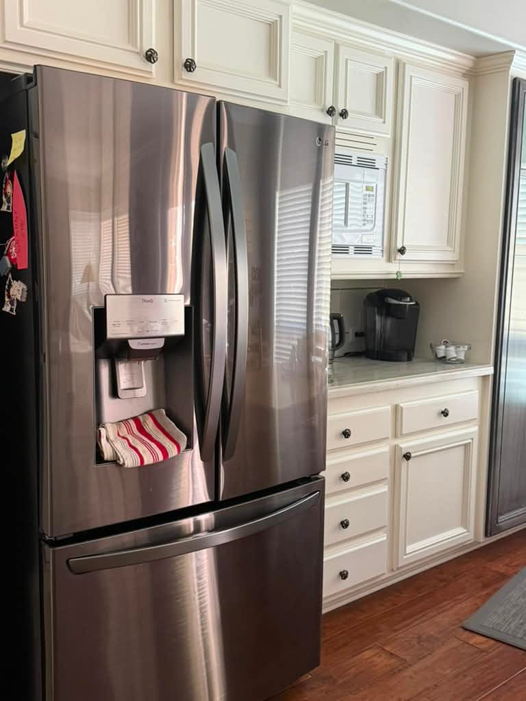 LG French-door refrigerator with a through-door ice and water dispenser panel, standing in a Rancho Santa Margarita kitchen with cream cabinetry, after a water filter and water filter housing replacement
