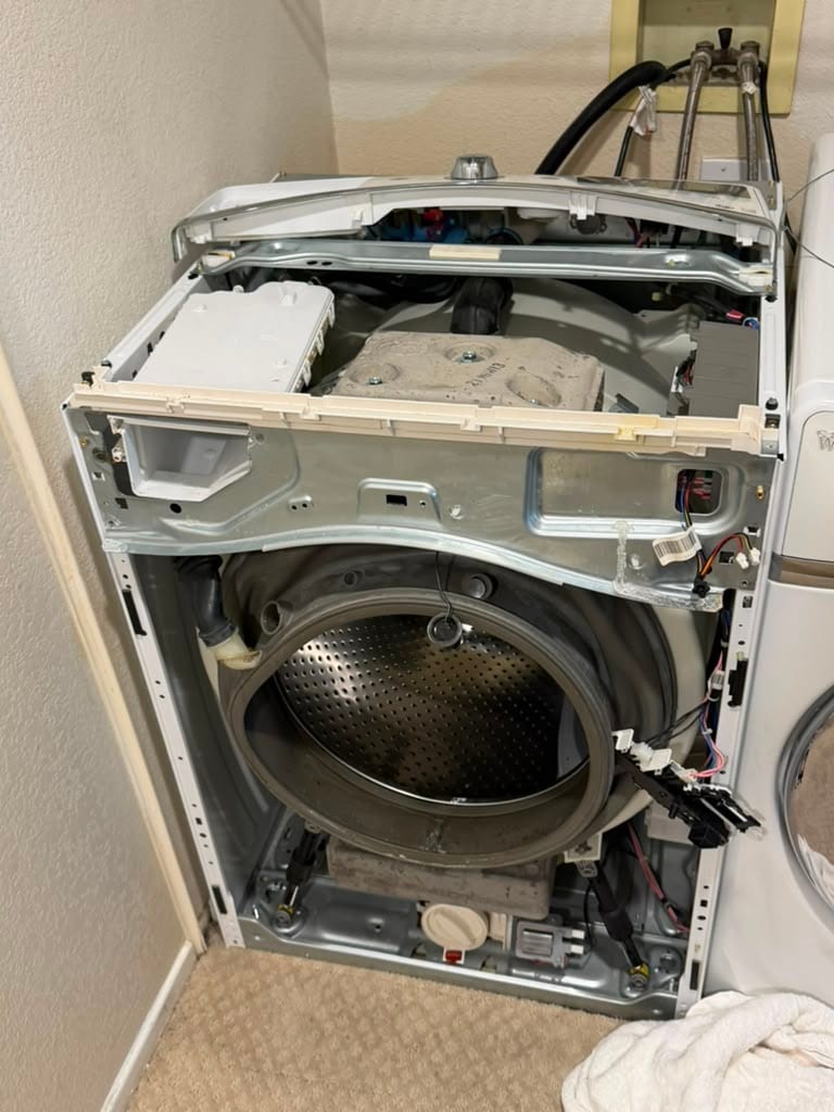 Whirlpool front-load washer opened up with the cabinet removed to reach the drum and door boot during an Aliso Viejo repair